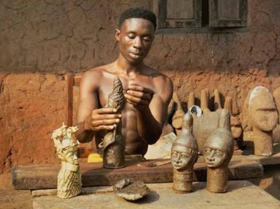 Master metalworker demonstrating lost-wax casting techniques at an arts center in Ife Nigeria