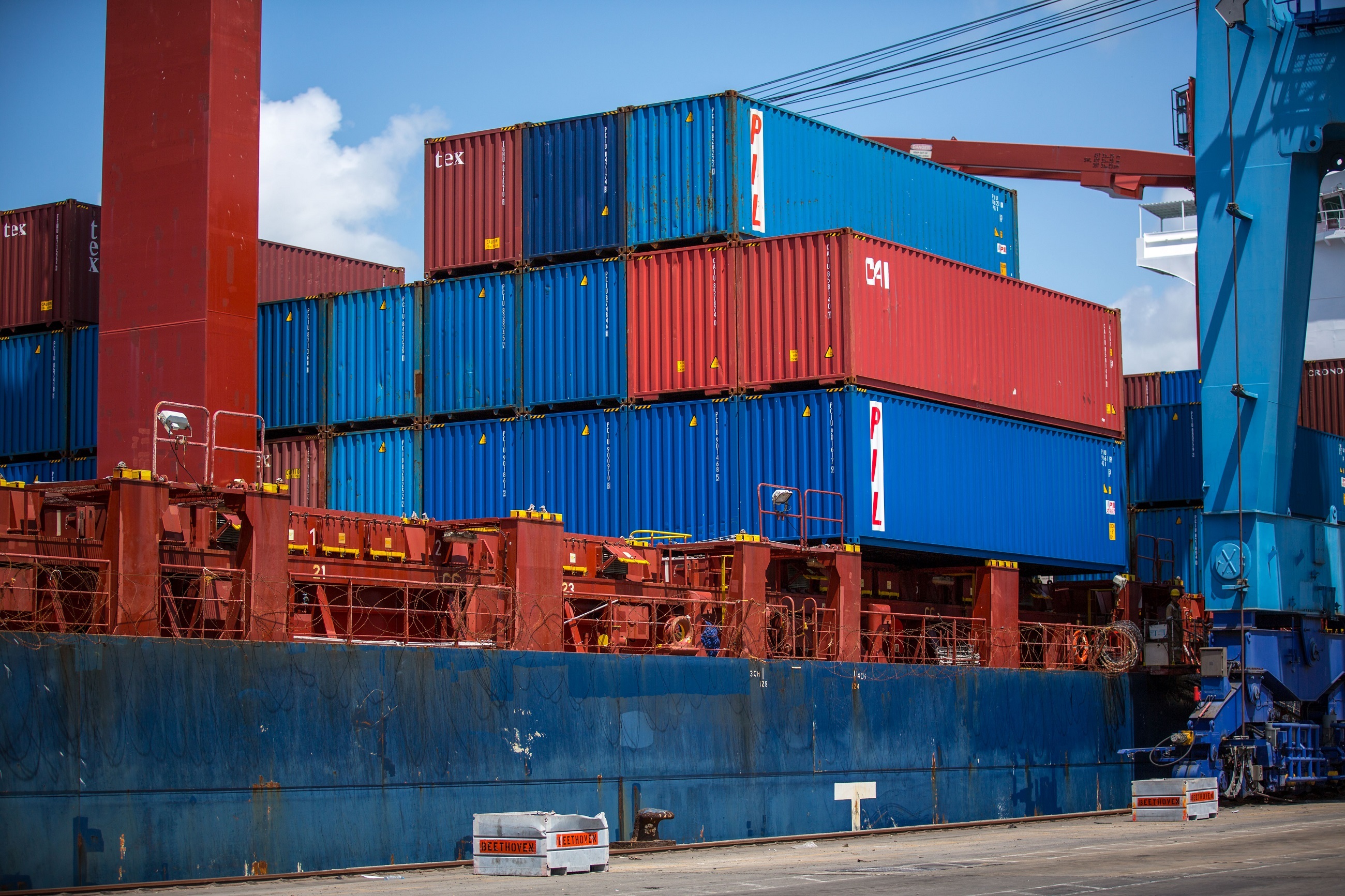 Container ships and port shipping infrastructure docked at a terminal.