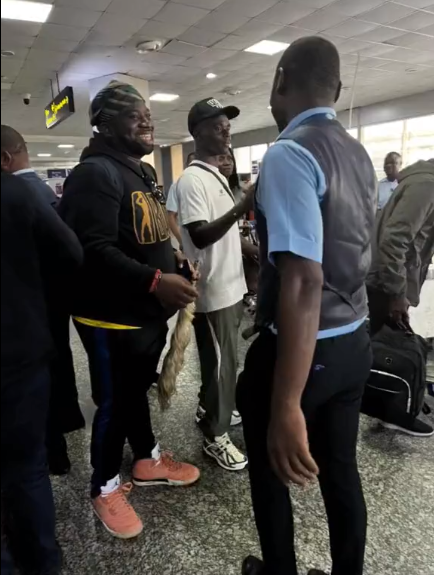 Travelers and staff interacting at a bustling airport terminal in Lagos, Nigeria.