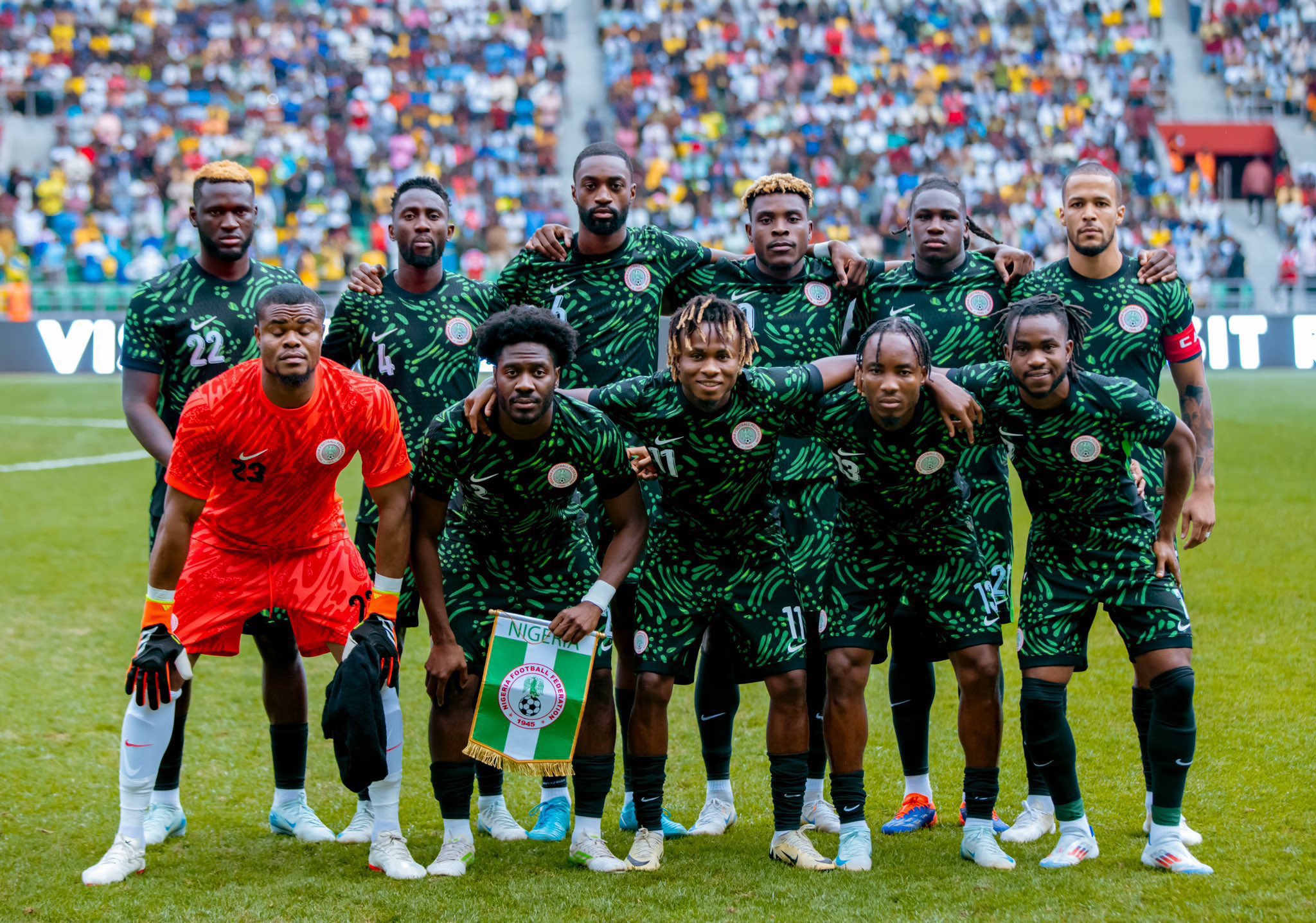 The Super Eagles starting lineup posing for a team photo on the pitch.