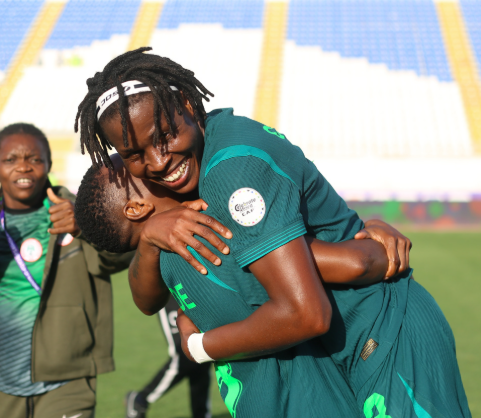 Osinachi Ohale hugging a young footballer.