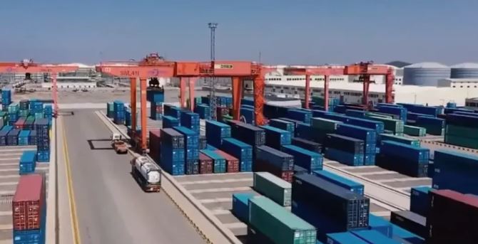 Shipping port containers and logistics cranes at a harbor.