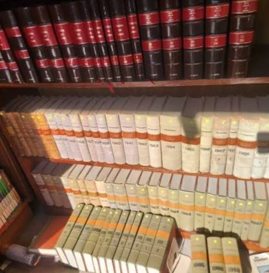 Rows of bound law books and legal volumes neatly arranged on wooden shelves.