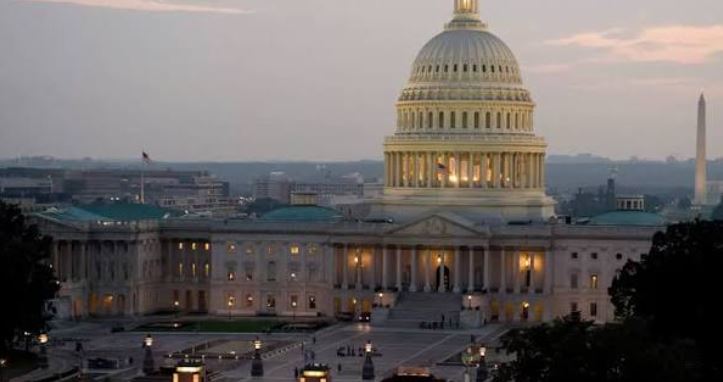 Exterior view of the United States Capitol building illuminated at dusk.