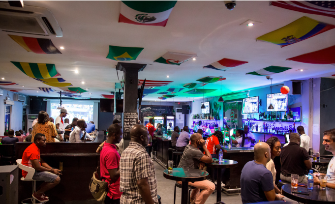 A sports bar setup displaying live European football coverage in Accra, Ghana.