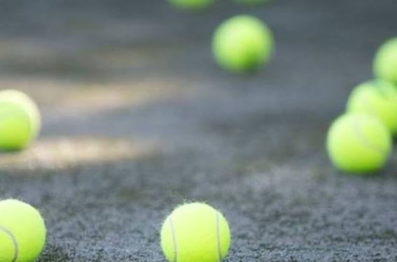 Close-up of yellow tennis balls resting on a hard court surface