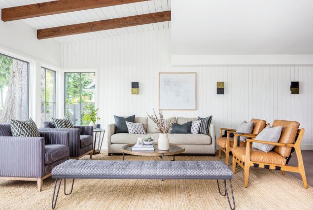 Bright modern living room space featuring a layered furniture arrangement and natural lighting.