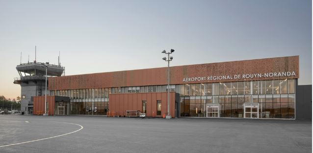Glass-walled airport terminal exterior during the day.